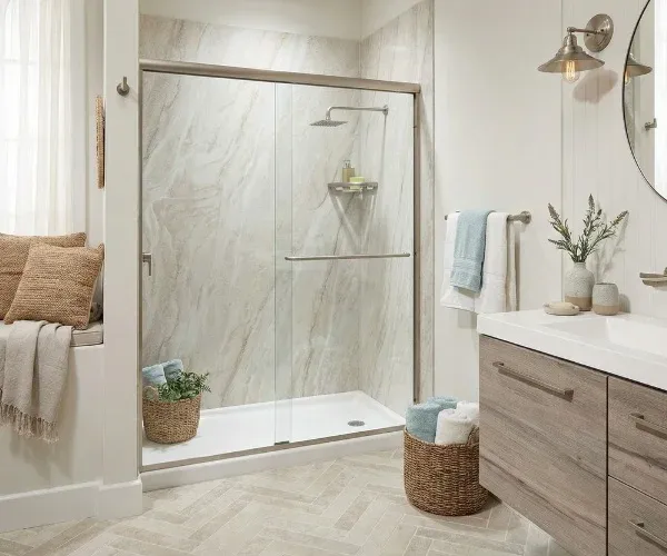 Walk-in shower with a sliding glass door where a tub used to be, beside a window seat