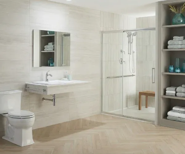 Aging-in-place bathroom with a wall-mounted sink, a glass walk-in shower and a shower stool