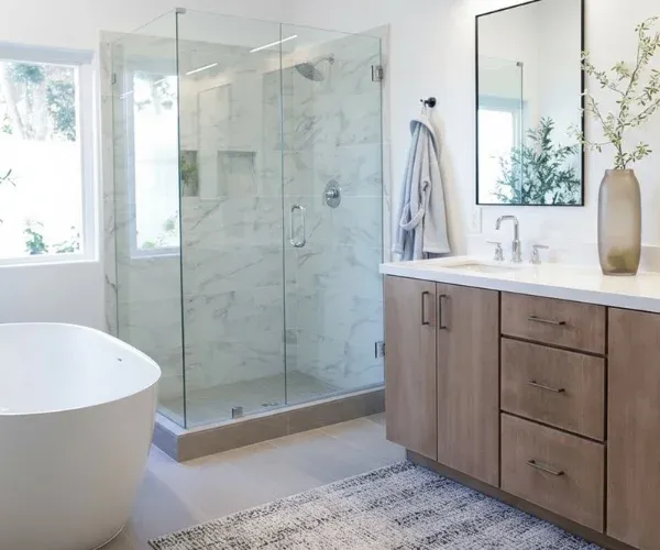 Primary bathroom with a glass-enclosed shower, a freestanding tub and a wood vanity