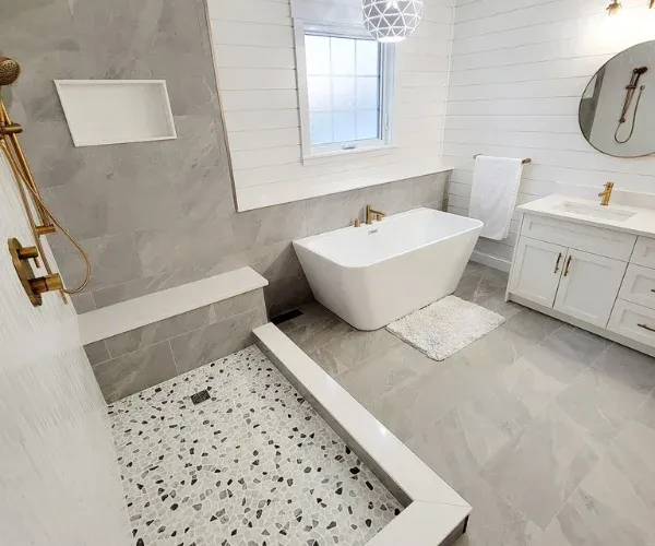 Bathroom remodel in Wilmington, NC with a pebble-floor walk-in shower and a freestanding tub