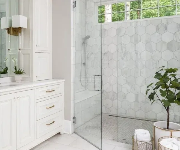 Shower remodel with frameless glass, marble hexagon tile and a transom window