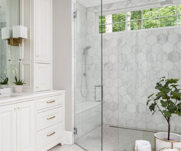 Modern walk-in shower with marble tile and built-in bench, used to compare value between tubs and walk-in showers in Wilmington, NC homes.